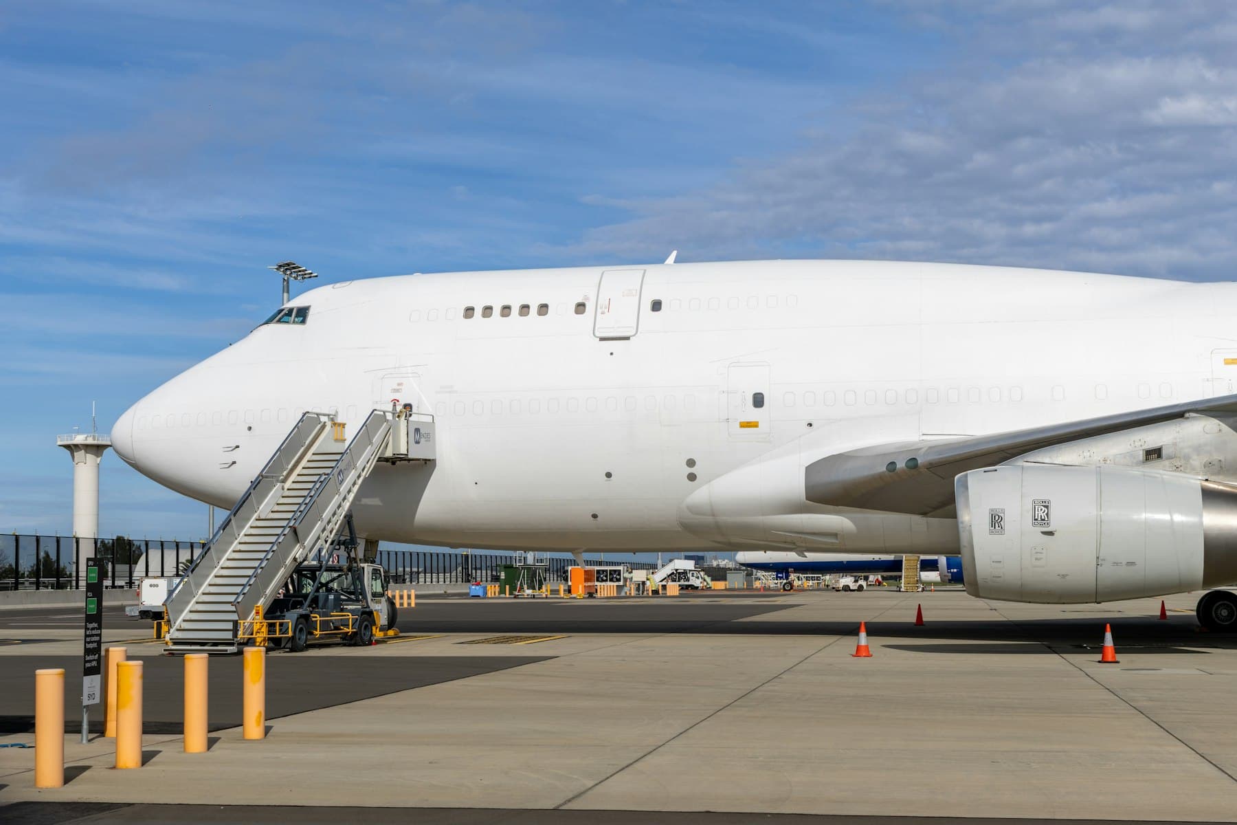 A white cargo jet on the airport apron with boarding stairs attached